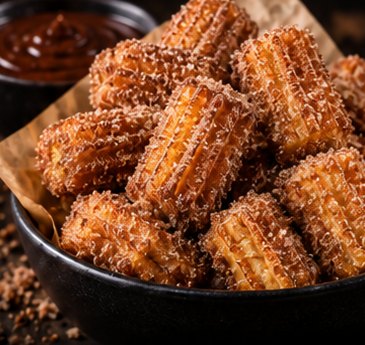 A bowl of cinnamon sugar churro bites with chocolate dip